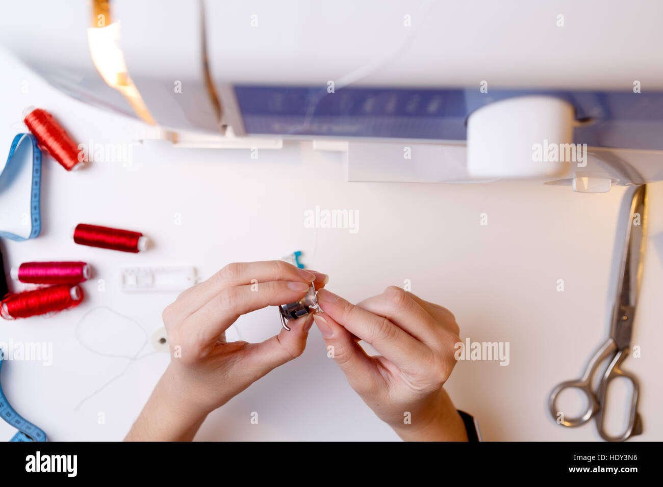 Woman fill bobbin sewing machine standing on table Stock Photo Alamy