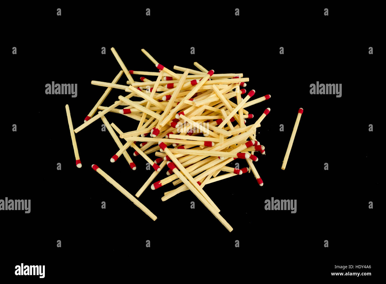 A pile of strike-anywhere matches isolated on a black background, photographed from the side Stock Photo