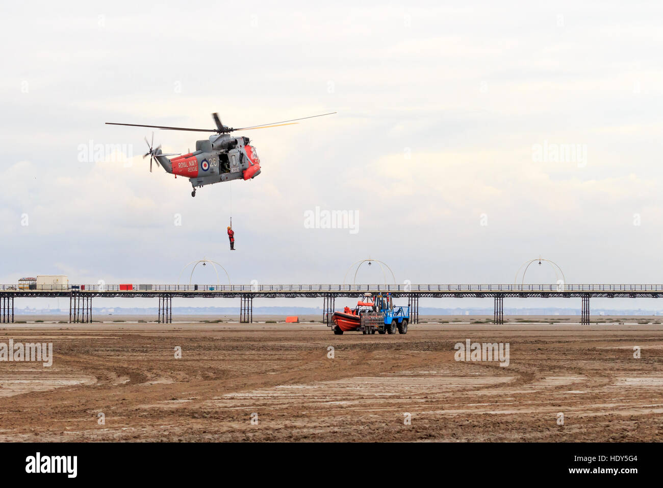 Royal Navy Seaking Search and Rescue helicopter performing mock rescue with  crew member hanging from the winch Stock Photo - Alamy