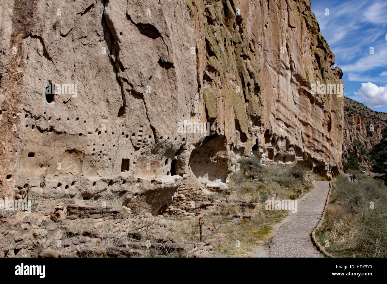 Path in Bandelier leads to rivers, petroglyphs, dwellings carved into the soft rock cliffs, and the remains of adobe dwellings Stock Photo