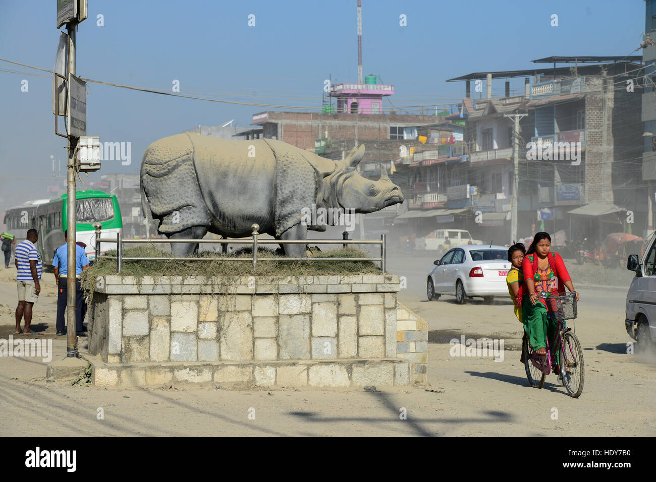 NEPAL, Terai, Chitwan Nationalpark, town Tandi, Rhino sculpture and damaged road with dust / Nepal, Terai, Chitwan Nationalpark, Stadt Tandi, Nashorn Skulptur und kaputte Strasse mit viel Staub Stock Photo