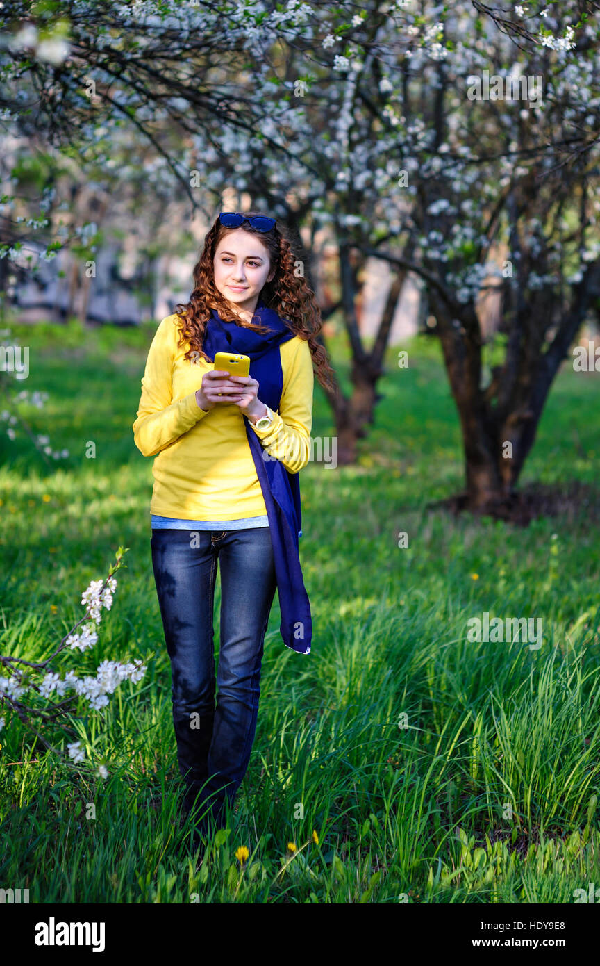 beautiful young woman walking in the park with your phone Stock Photo