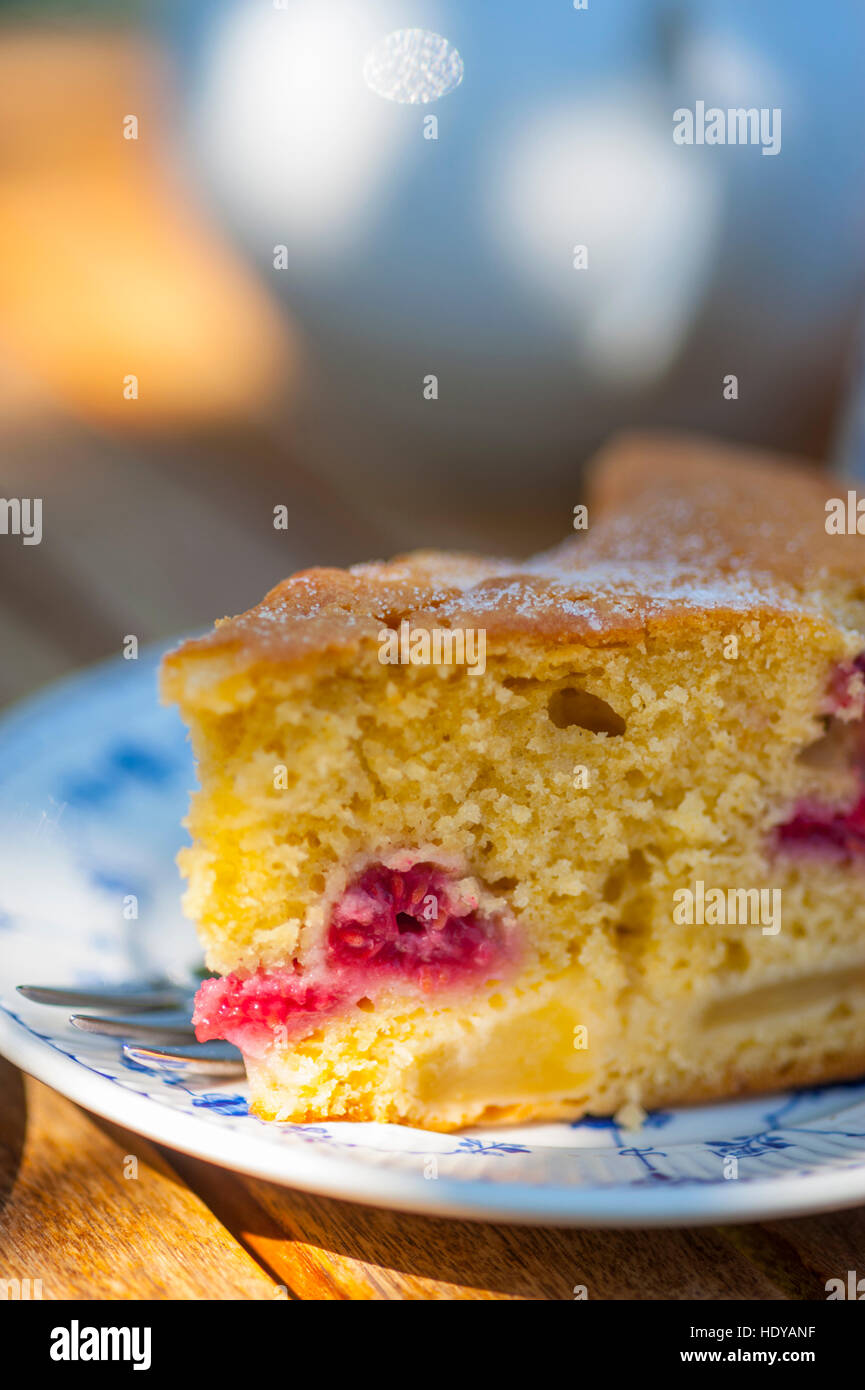 Piece of cake on a plate in the sunshine as part of an afternoon tea Stock Photo