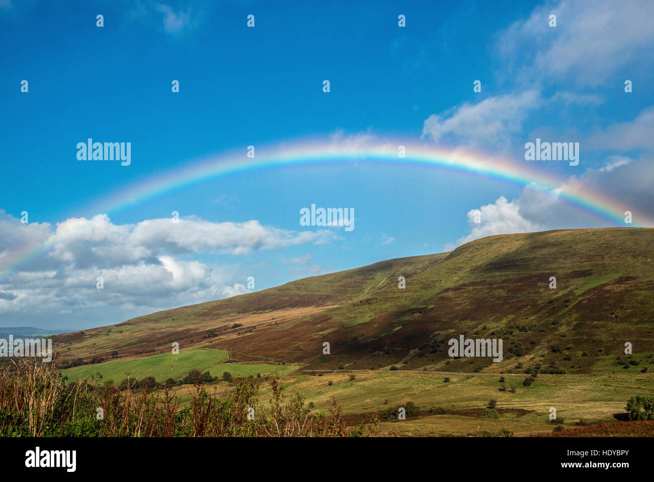 Rainbow across blue sky in the Brecon Beacons National Park, south Wales Stock Photo