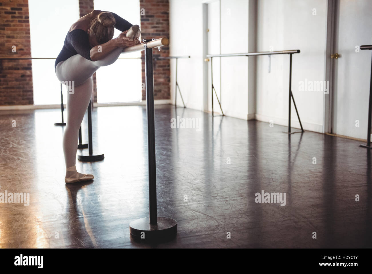 Ballerina stretching at barre in ballet studio Stock Photo Alamy