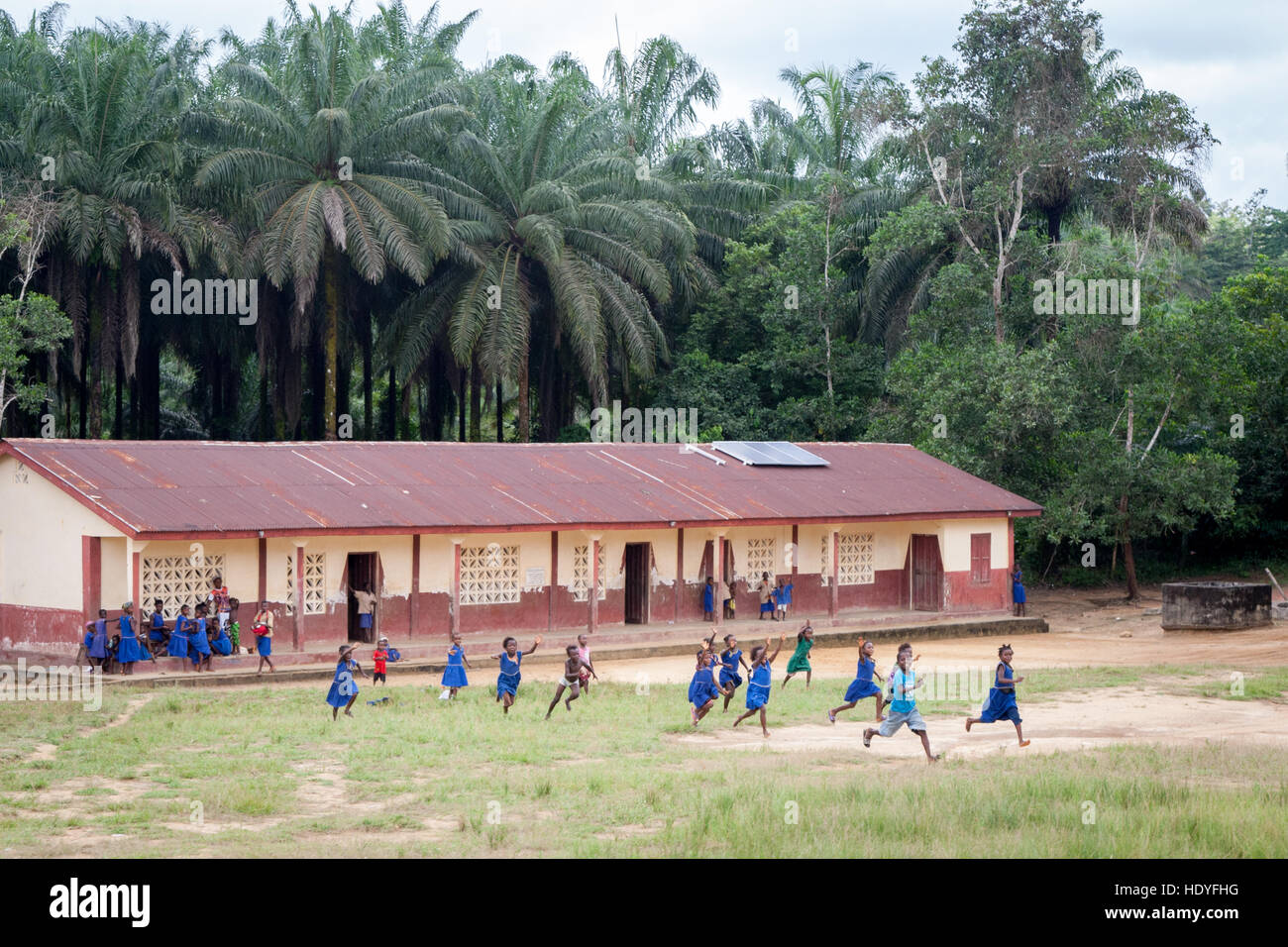 Students running from primary school in Sierra Leone. Students can't keep their seats when they spot us in the car Stock Photo