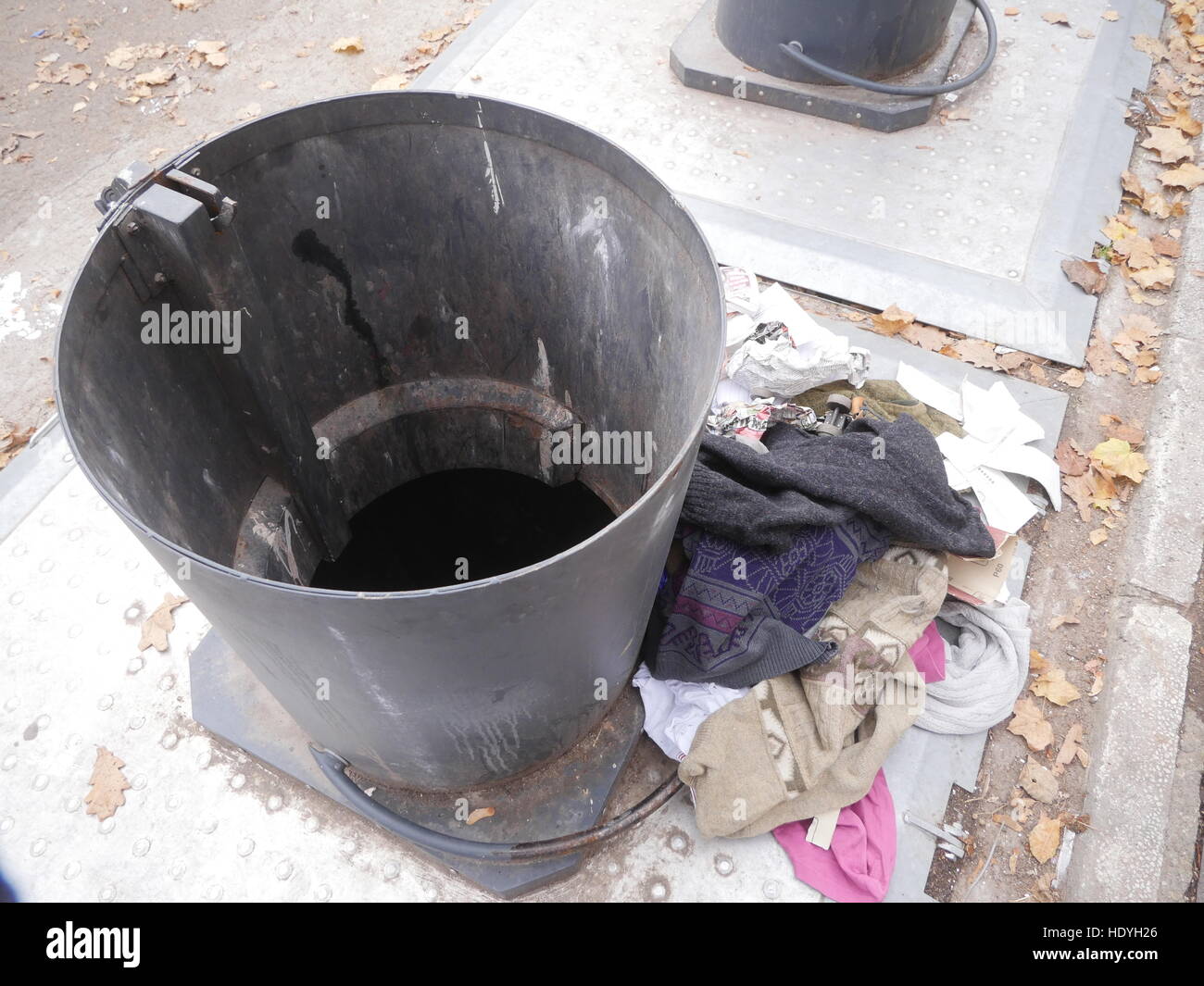 Garbage can with old clothes on the side Stock Photo Alamy