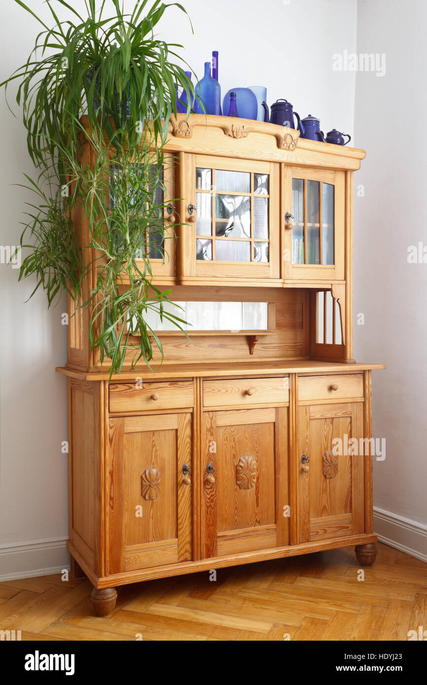 Old pine cupboard with wooden and glass doors, drawers, on oak herringbone parquet flooring, nostalgic furniture Stock Photo