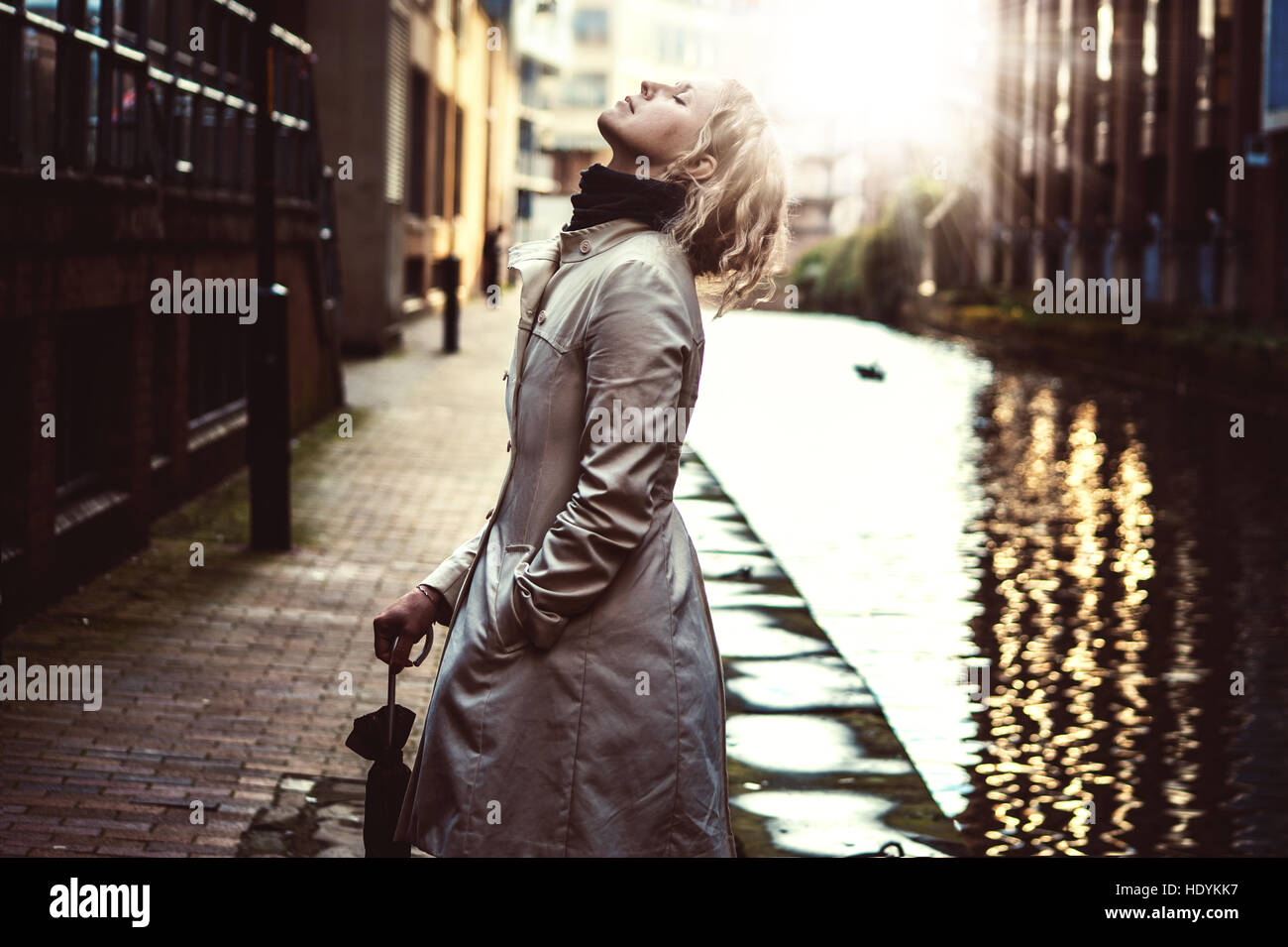 dreamy image with woman with umbrella by the water Stock Photo