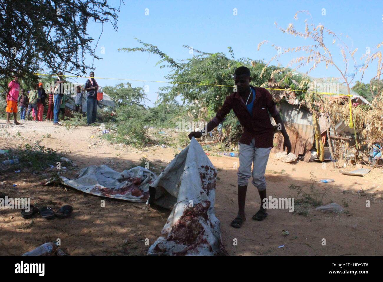 Mogadishu, Somalia. 15th Dec, 2016. A man inspects a bloody blanket at the scene of a landmine