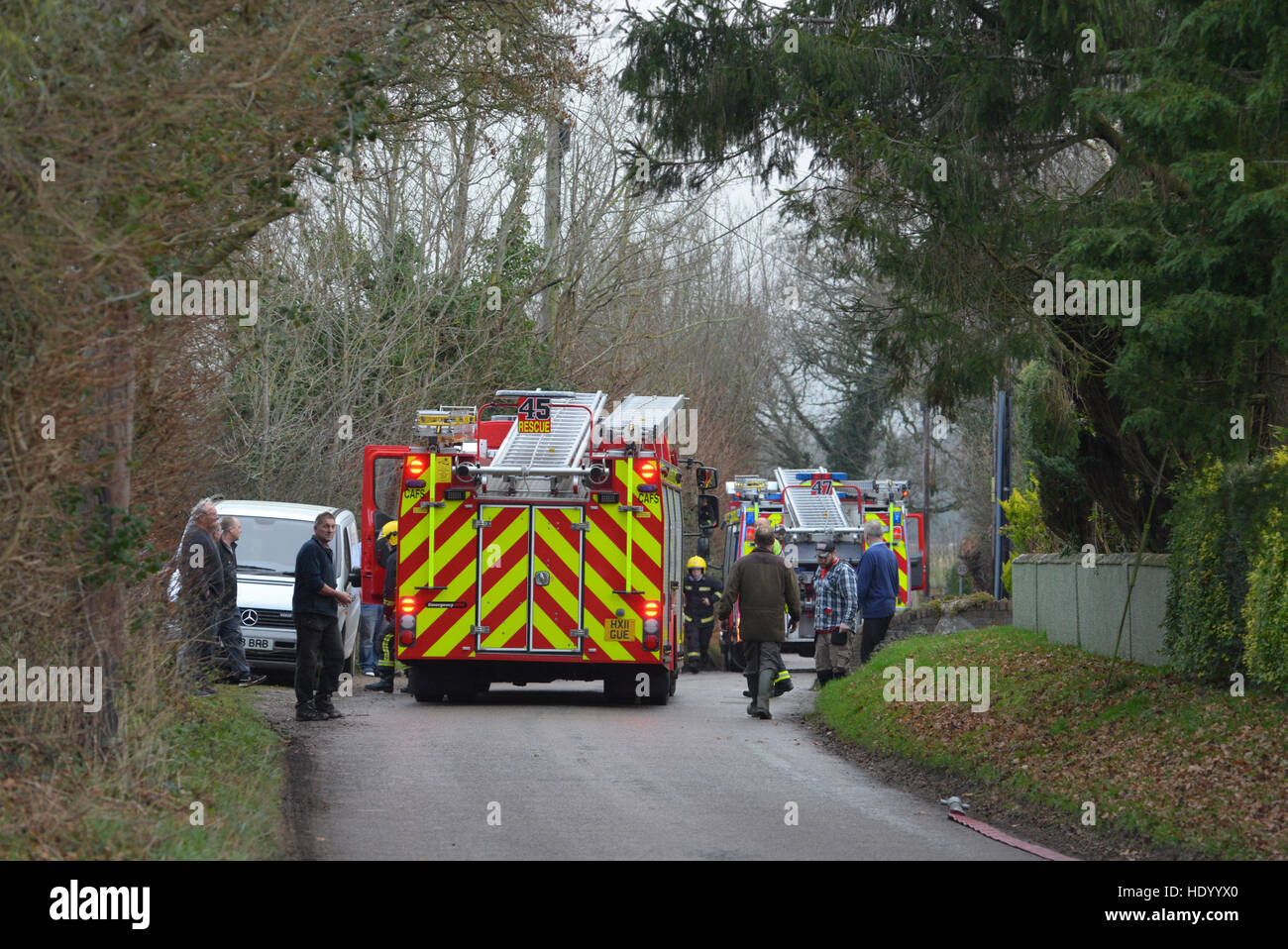 Fire brigade attending a fire at a rural property on a country lane. Stock Photo