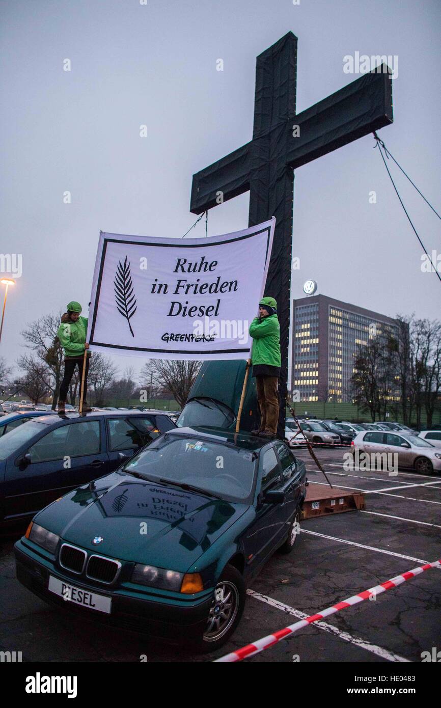 Wolfsburg, Germany. 16th Dec, 2016. Activists of Greenpeace have hung up a banner reading 'Rest in Peace Diesel' in front of a Volkswagen administrative building in Wolfsburg, Germany, 16 December 2016. The environmental organisation has erected a cross ten metres high along with several wrecked cars of different producers on the parking space in front of Gate 6 of the Volkswagen Factory. A year after the Diesel Scandal of Volkswagen, activists are urging all automtive producers to cease using Diesel technologies. Photo: Philipp von Ditfurth/dpa/Alamy Live News Stock Photo
