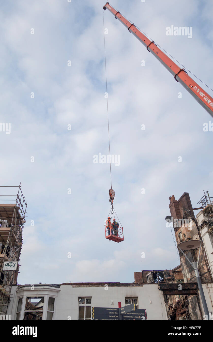 Exeter,UK. 16 December 2016. Demolition of Royal Clarence Hotel. Workers dangling from a huge crane jib.Work continues to demolish Britain's oldest hotel in the city's historic Cathedral close destroyed in a tragic fire. Demolition won't be completed until March 2017.These two workers aren't just hanging around Credit: Anthony Collins/Alamy Live News Stock Photo