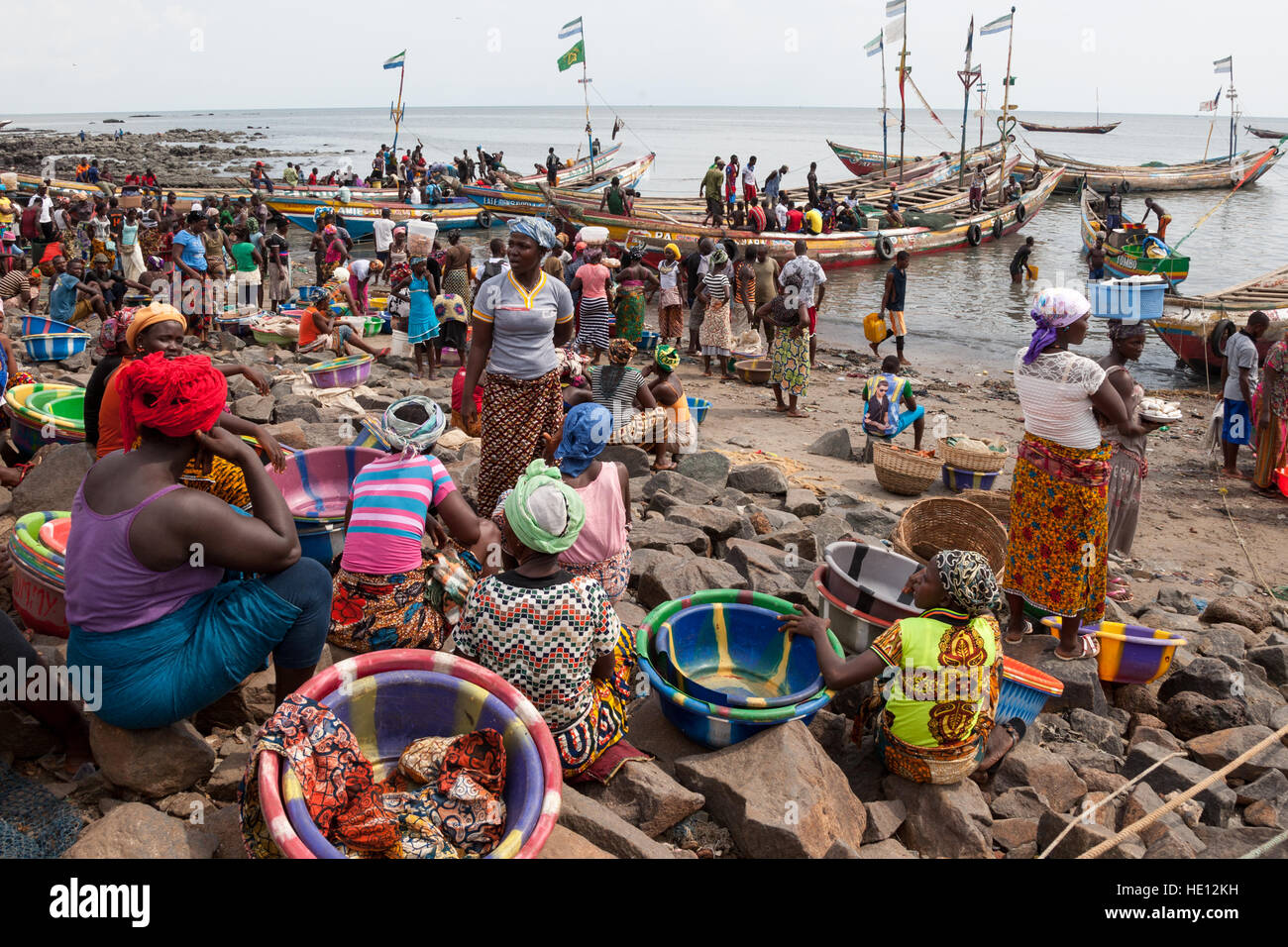 Busy traffic on beach in Tombo Harbour, Sierra Leone. Women are waiting for more fishing boats to arrive. Stock Photo