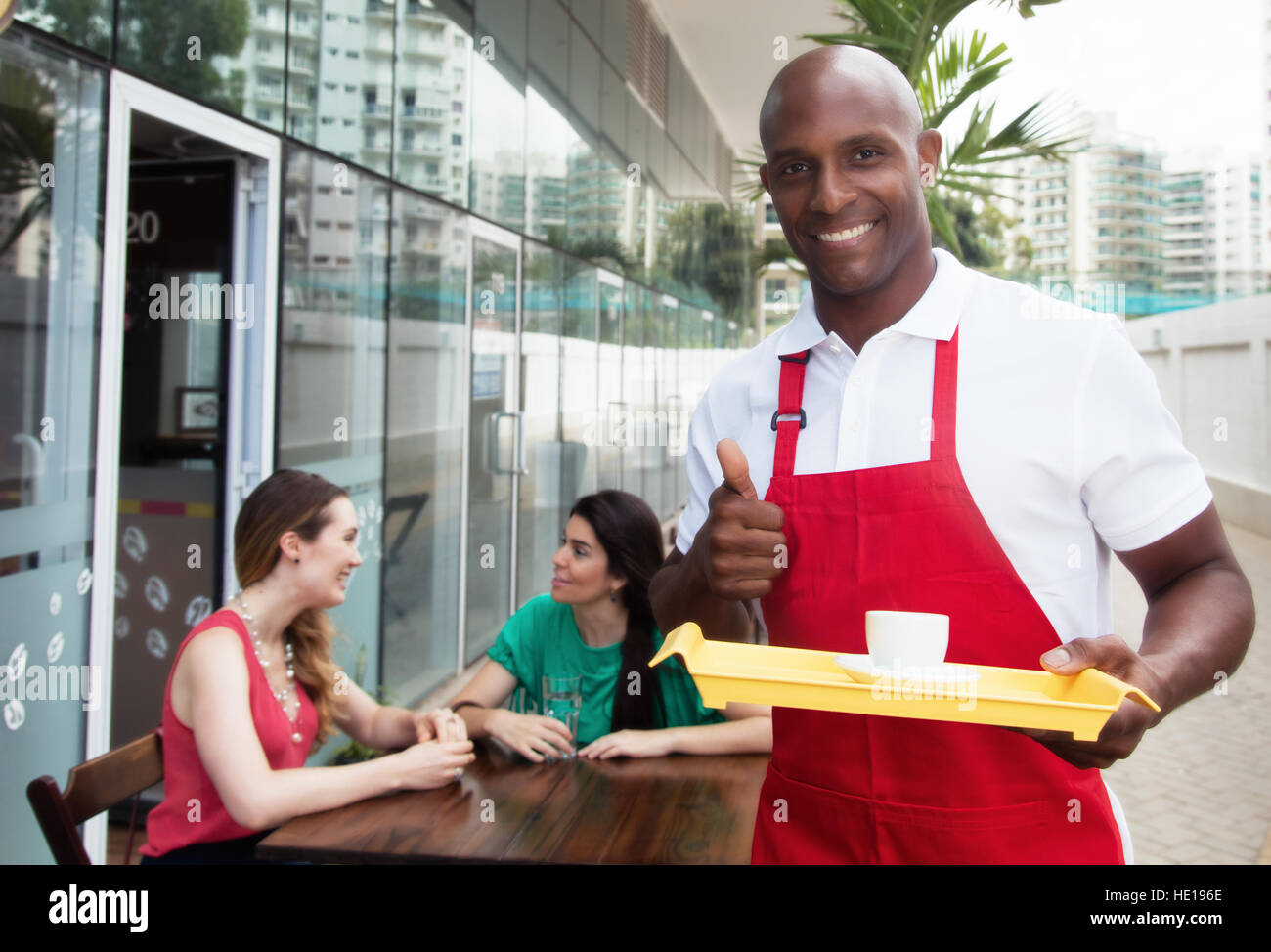 Handsome african american waiter at work in a restaurant with guests