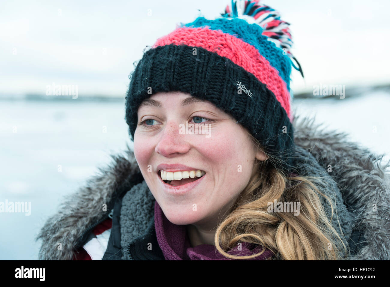 Young woman wearing woolly hat, laughing, portrait, Fjallsárlón Glacier Lagoon, Iceland Stock Photo