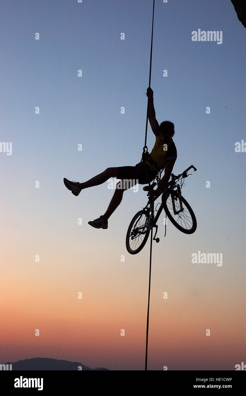 Extreme sports, man roping, rappelling with a bike at sunset, Mt.  Losenstein, Upper Austria, Austria, Europe Stock Photo - Alamy