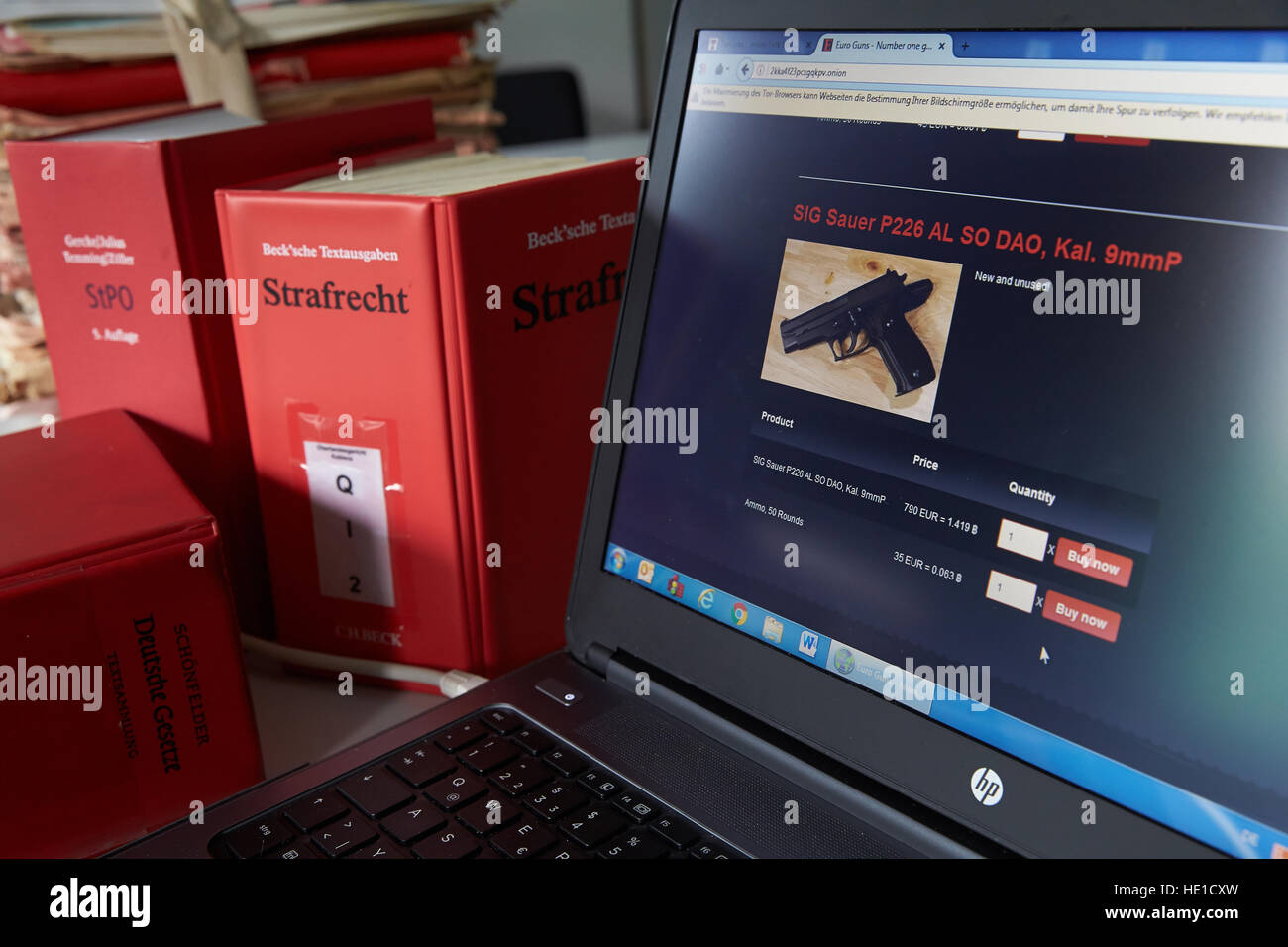 Laptop screen, Darknet firearms website, criminal law books, Germany Stock Photo