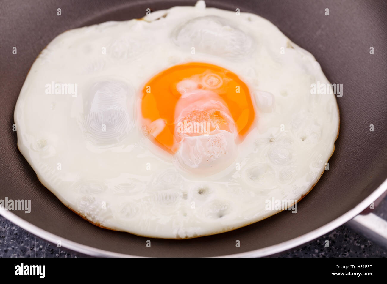 Fried egg on pan closeup picture. Stock Photo