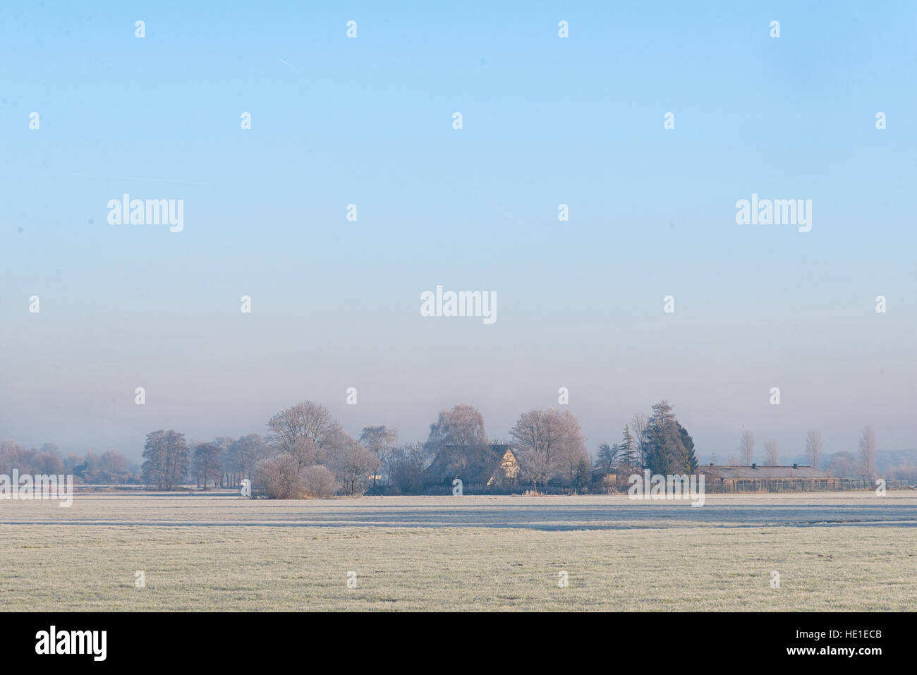 Dutch rural winter landscape with frozen meadow and a farm Stock Photo