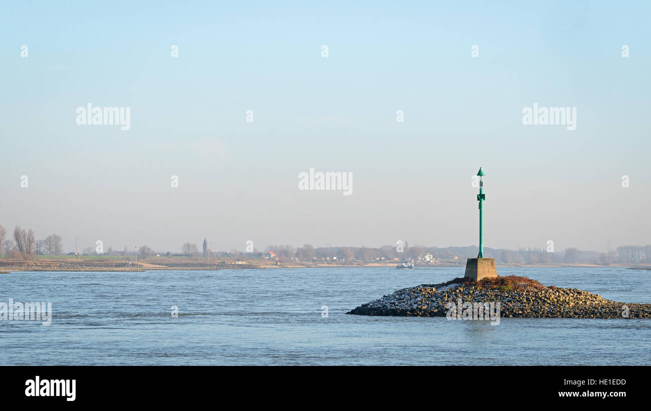 Green beacon in the river Waal in the evening sun Stock Photo