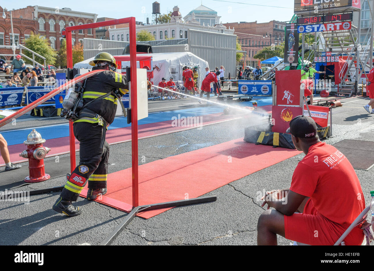 A firefighter completing a timed event with a fire hose. Stock Photo