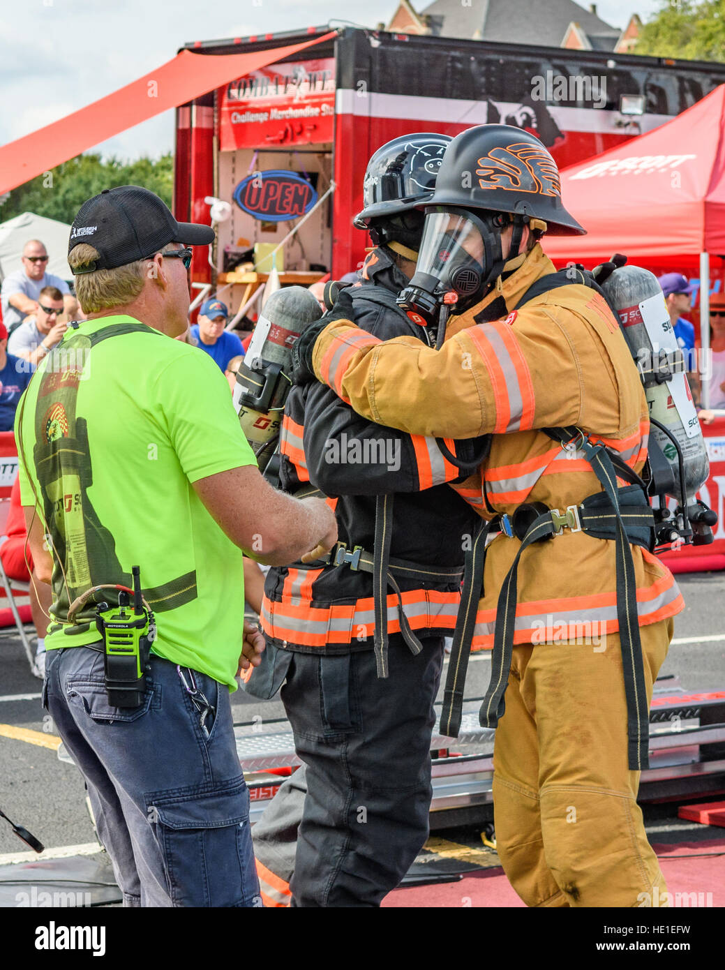 Firefighters hug before competition event. Stock Photo