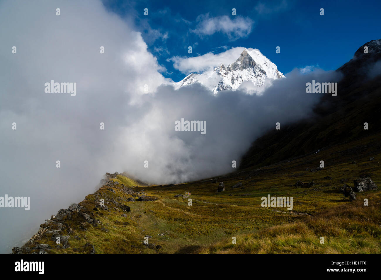 View on the summit of the mountain Machapuchare, partly covered by monsoon clouds Stock Photo