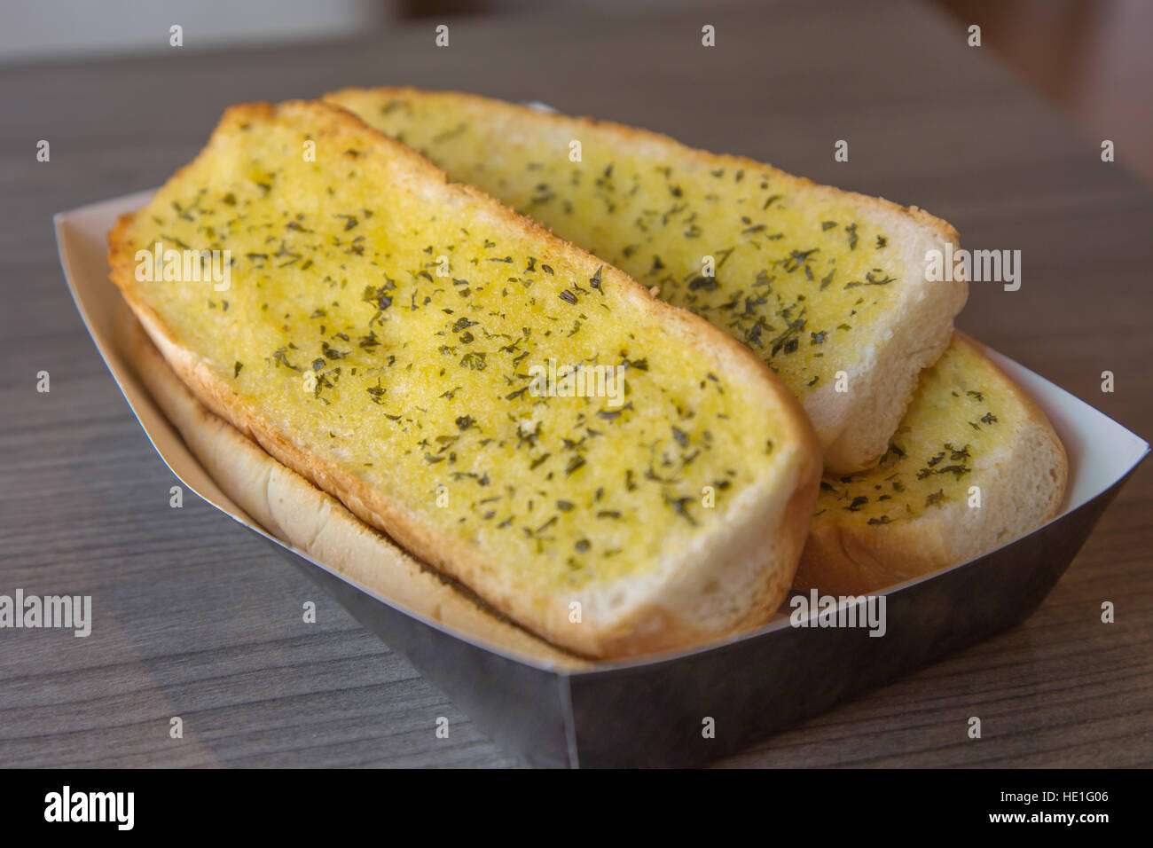Close up of crunchy garlic baguette on the wooden table. Stock Photo