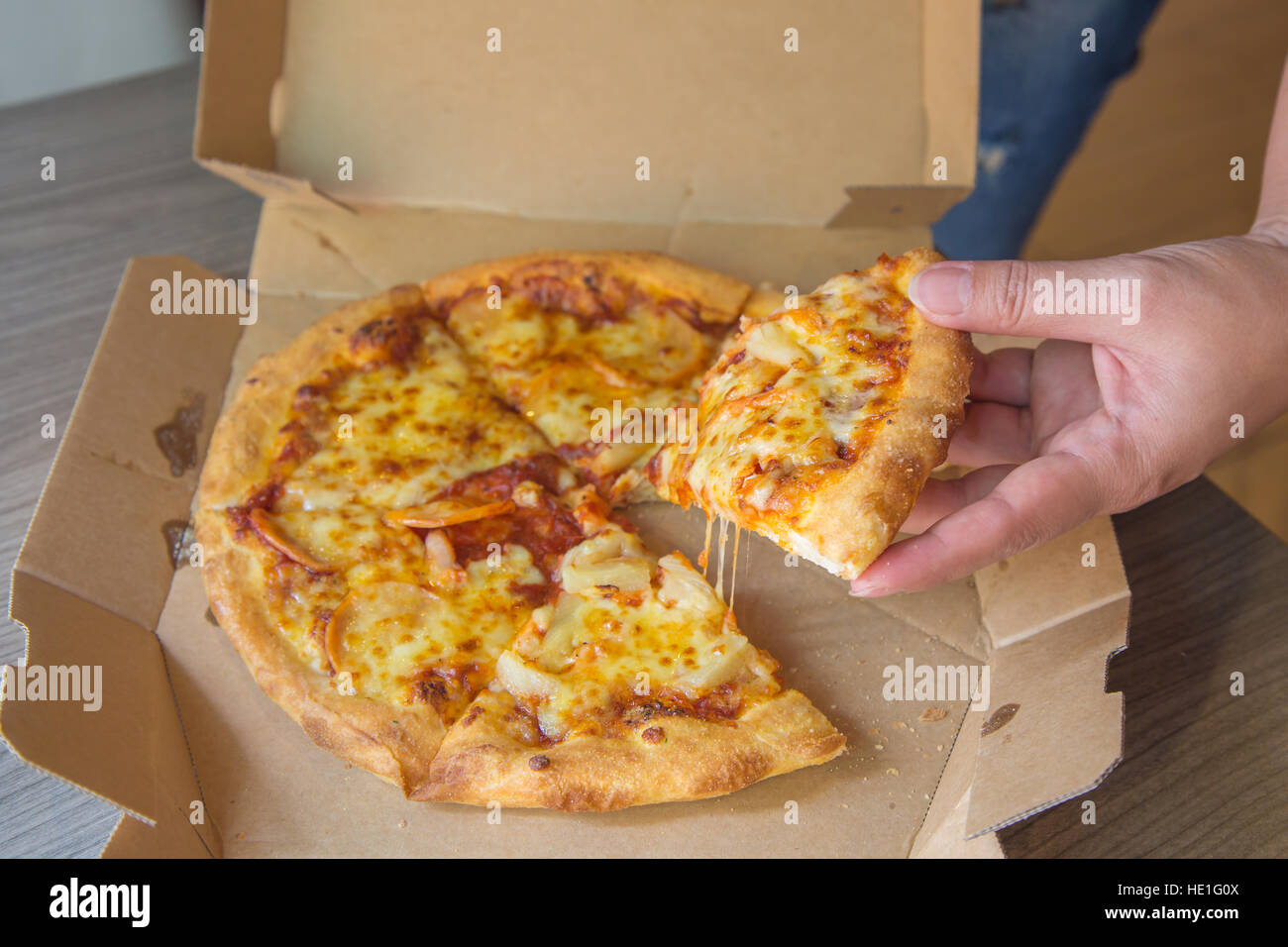 Hand hold Pizza in the open boxes for ready to eat. Stock Photo