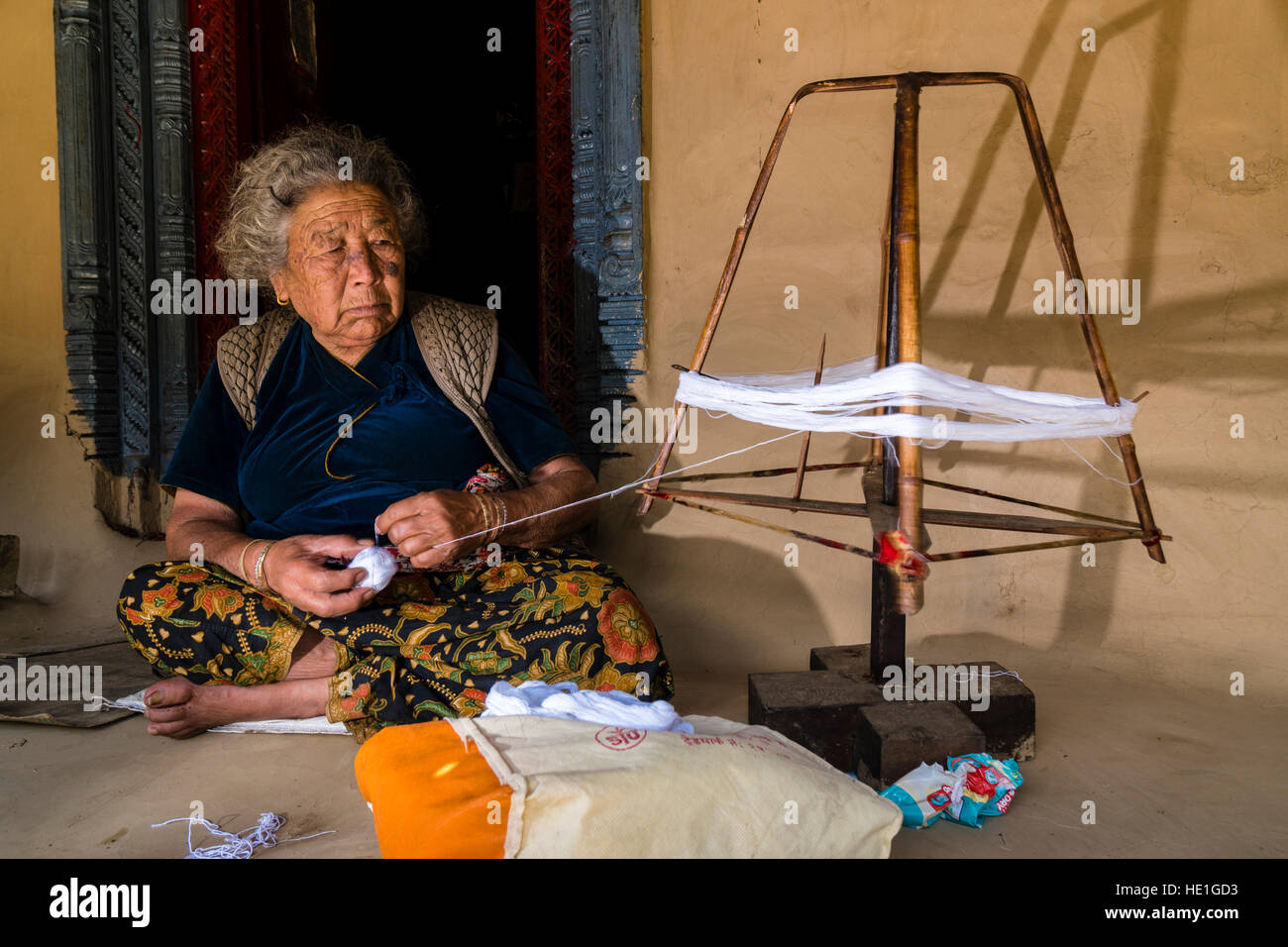A local woman is spinning sheep wool with a traditional spinning wheel ...