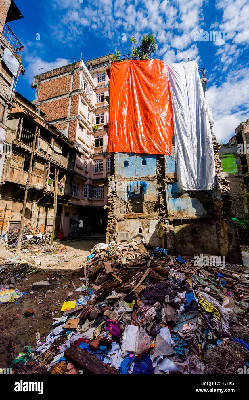 A building in the city got damaged during 2015 earthquake and is covered by plastic sheets Stock Photo