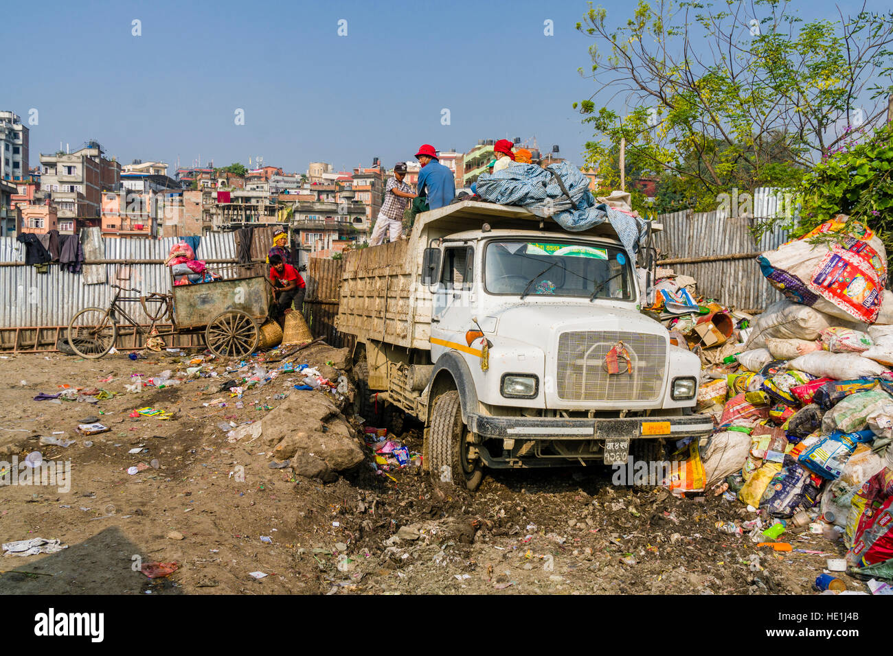 People are collecting garbage in the city, loading it on trucks and transporting it to a garbage dump outside the town Stock Photo