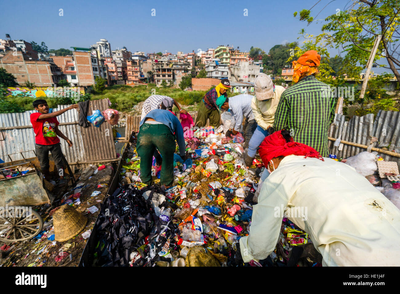 People are collecting garbage in the city, loading it on trucks and transporting it to a garbage dump outside the town Stock Photo