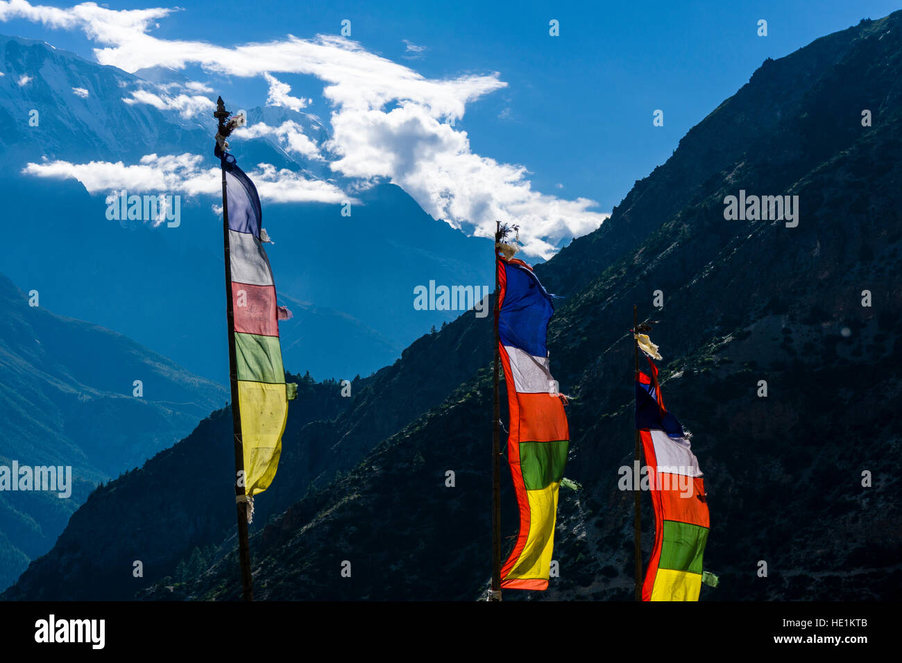 Colorful buddhist prayer flags at a mountain slope above the Upper Marsyangdi valley Stock Photo