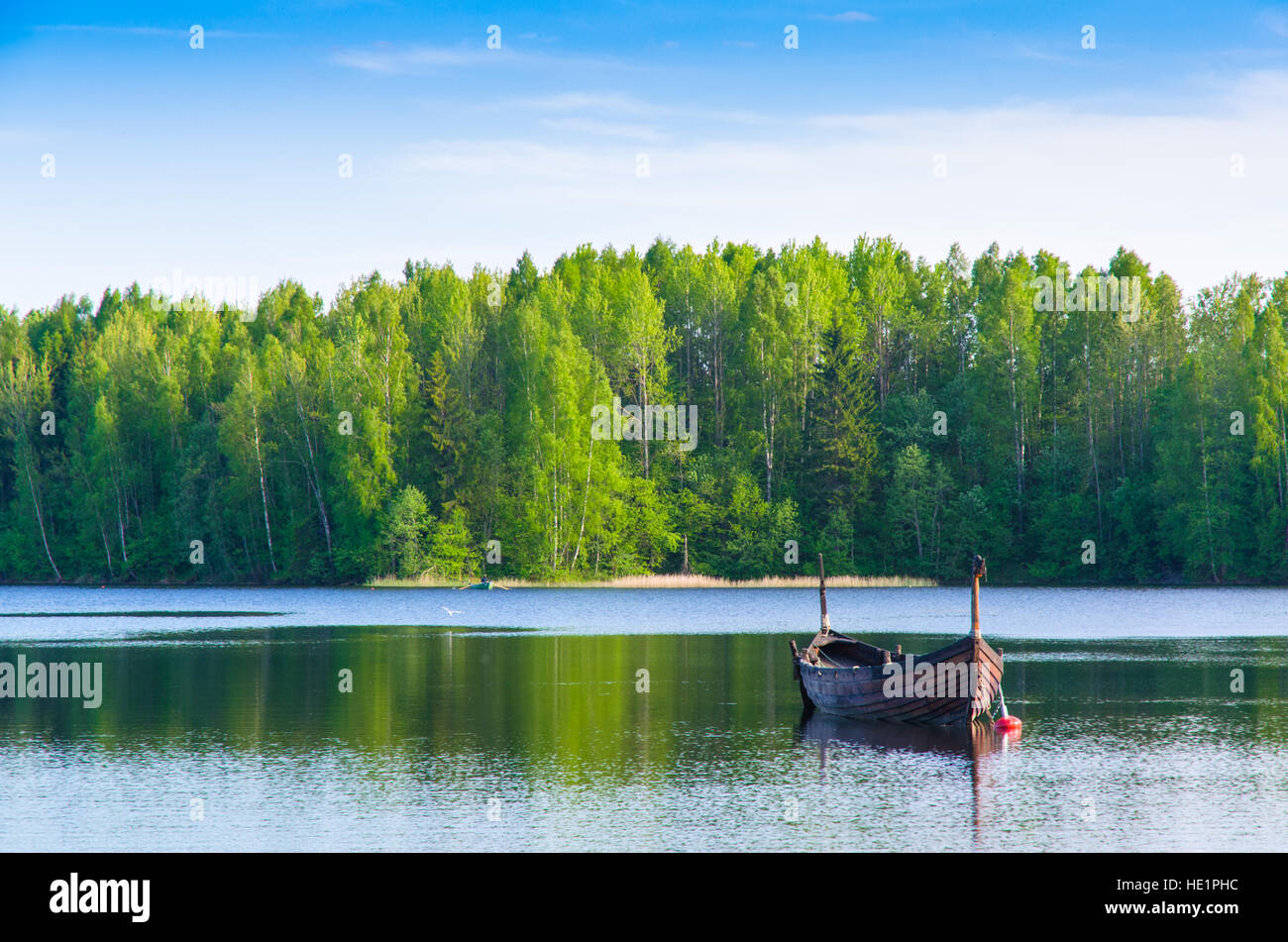 A fishing boat anchored in a forest lake Stock Photo