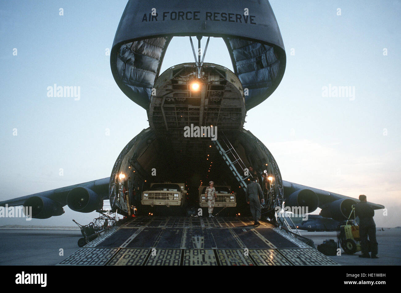 Military trucks are unloaded from the nose ramp of a C5A Galaxy transport aircraft of the U.S Military trucks are unloaded from the nose ramp of a C5A Galaxy transport aircraft of the U.S