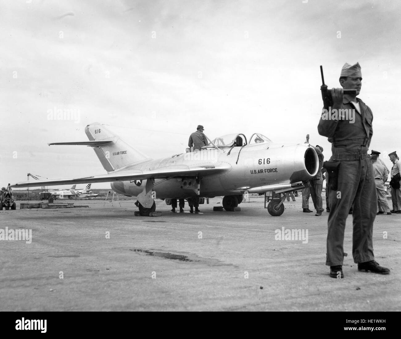 Under constant guard by Air Police at a U.S. Air Force installation on Okinawa, reassembly of the MIG-15 is completed on the flight line.   After careful ground testing, the Russian-built fighter was flown by five U.S. Air Force pilots during a week of extensive tests.  October 1953. Stock Photo