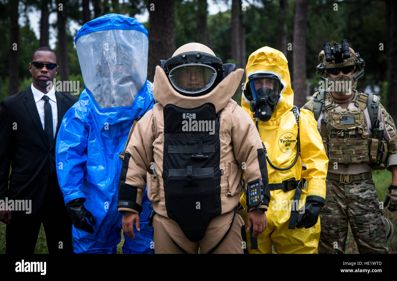Explosive Ordinance Disposal teams have multiple roles within their job. Besides the obvious capabilities of an EOD bomb suit, there is other specialized equipment and protective gear that EOD teams employ to adapt to  their operational environment. EOD technicians are able  to engage in operations in a chemical or nuclear environment or in urban warfare scenarios. EOD also often works with the U.S. Secret Service.   Pictured from left, Staff Sgt. Darius Bailey, U.S. Secret Service, Staff Sgt. James Vossah, EOD Team Member in Level A Encapsulating HAZMAT Suit, Staff Sgt. Guadalupe Corona, wear Stock Photo