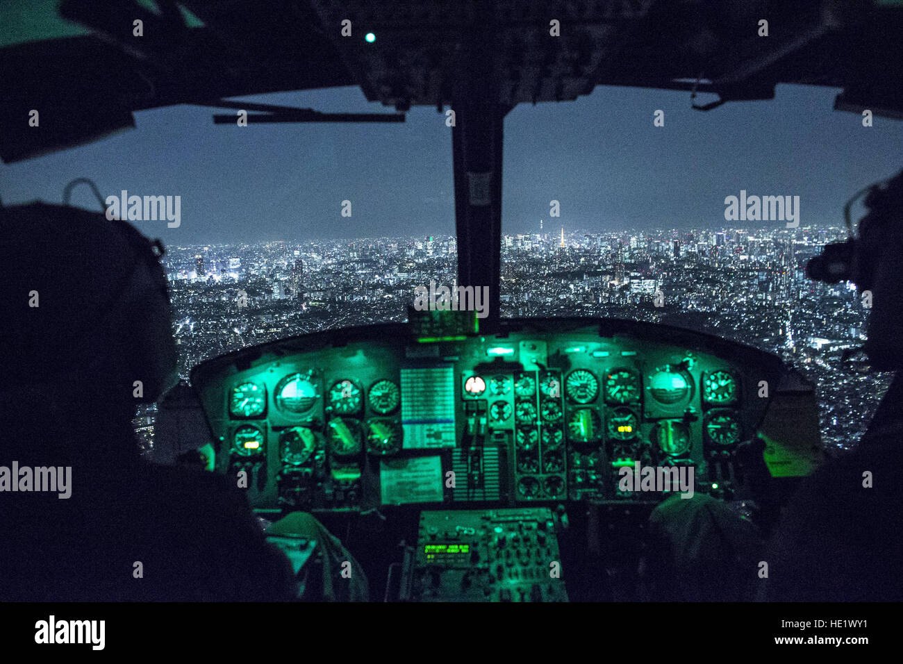 Capt. Jonathan Bonilla and 1st Lt. Vicente Vasquez, 459th Airlift Squadron UH-1N Huey pilots, fly over Tokyo after completing night training April 25, 2016. The 459th AS frequently trains on a multitude of scenarios in preparation for potential real-world contingencies and operations. /Yasuo Osakabe Stock Photo