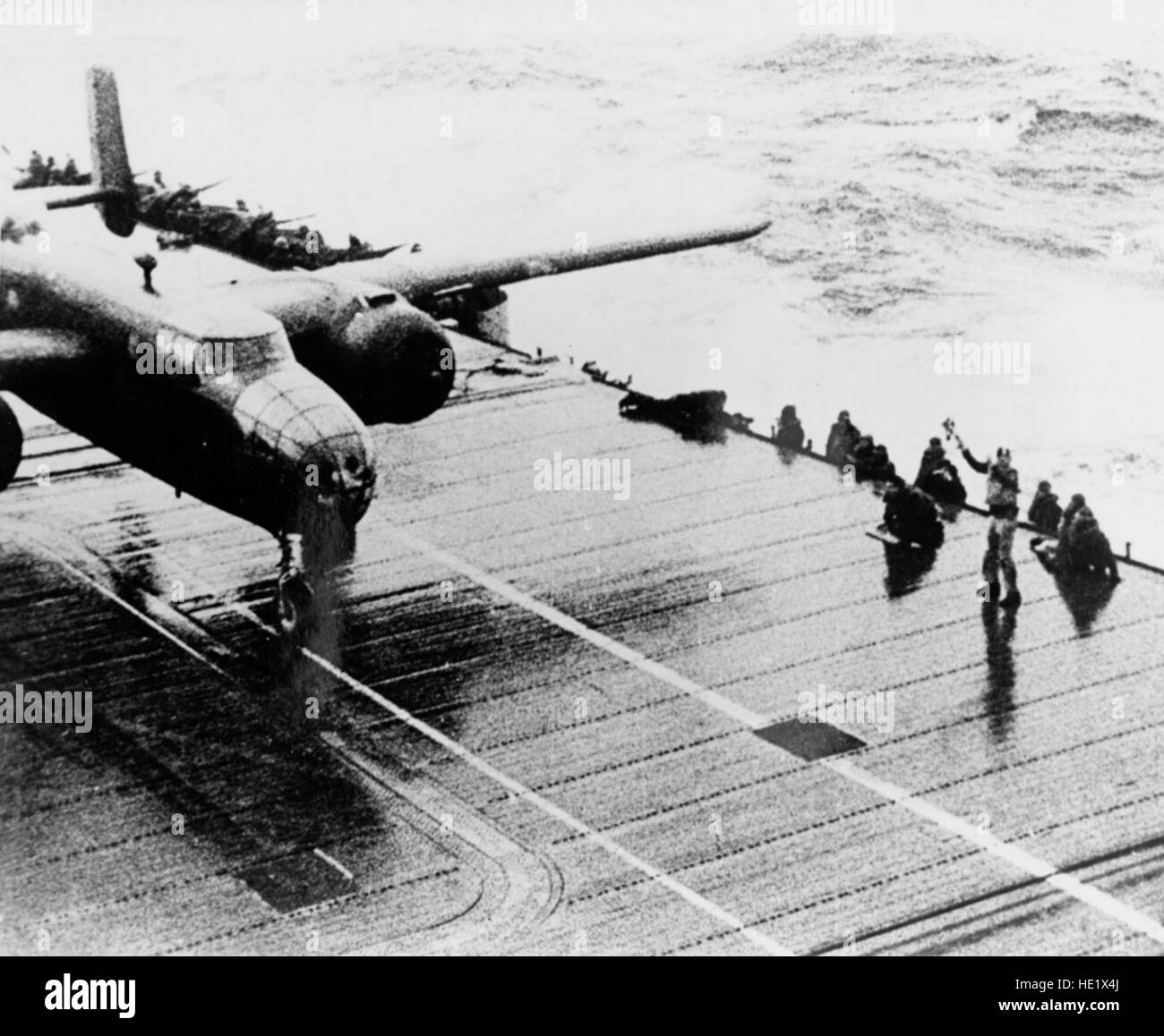 A B-25 begins its take off roll from the deck of the USS Hornet for the 'Doolittle Raid' on Tokyo, Saturday, April 18, 1942. The bombing attack by the United States of America on the Japanese capital Tokyo and other places on the island of Honshu during World War II, was the first air raid to strike the Japanese Home Islands. Sixteen B-25B Mitchell medium bombers were launched without fighter escort from the U.S. Navy aircraft carrier USS Hornet deep in the Western Pacific Ocean, each with a crew of five men. The plan called for them to bomb military targets in Japan, and to continue westward  Stock Photo