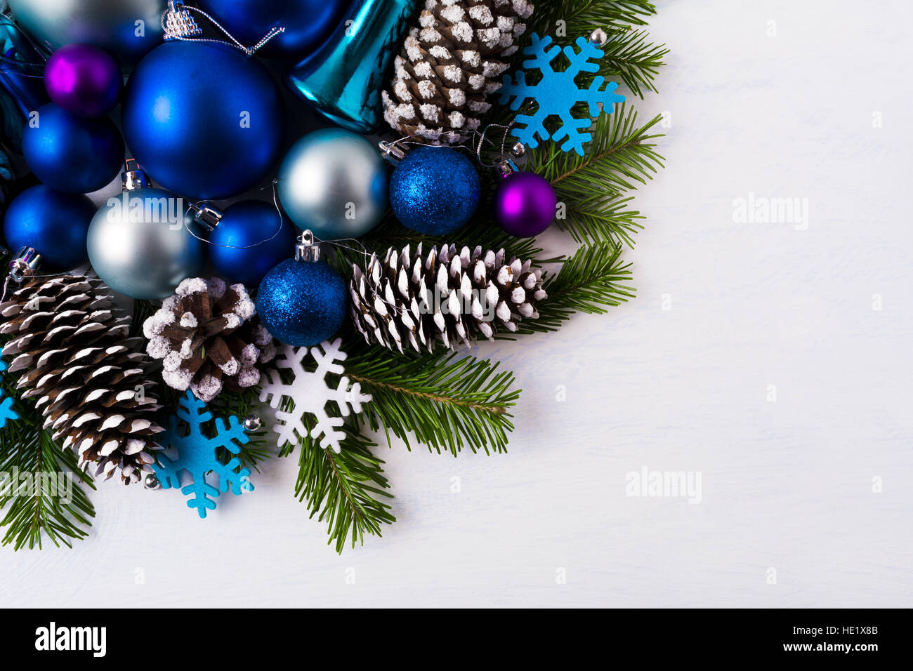 Christmas greeting background with blue and white felt snowflakes. Christmas decoration with blue color shades ornaments and snowy pine cones. Copy sp Stock Photo