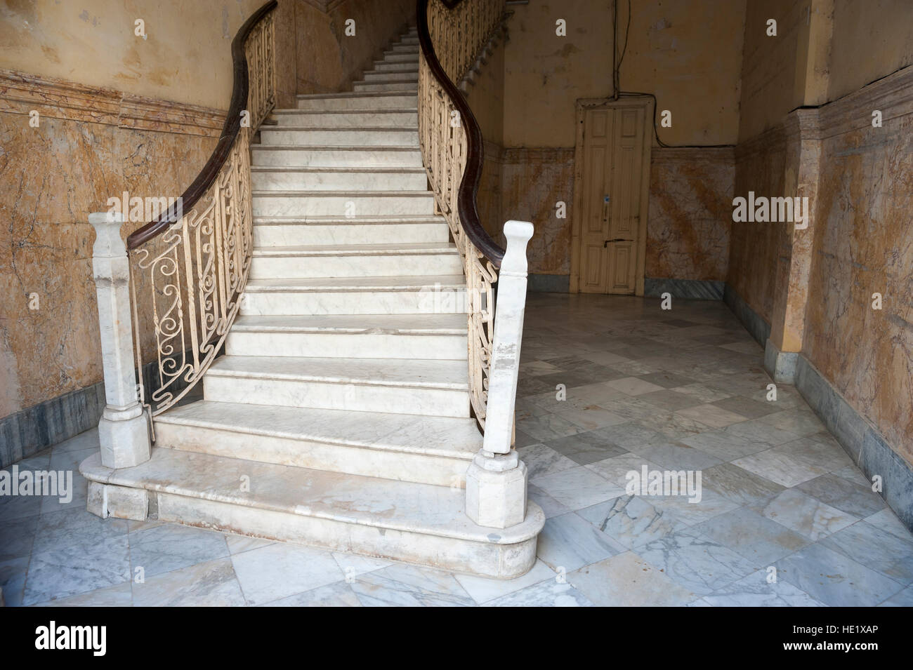 Grand staircase with eye-catching curving bannisters leads from the ground floor of a classic colonial building in Havana, Cuba Stock Photo
