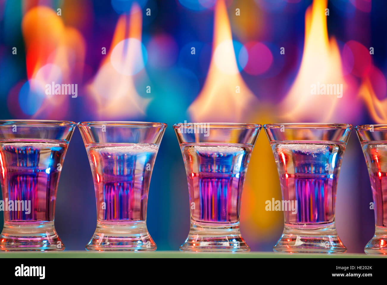 Hot shot glasses standing in a row on bar counter Stock Photo