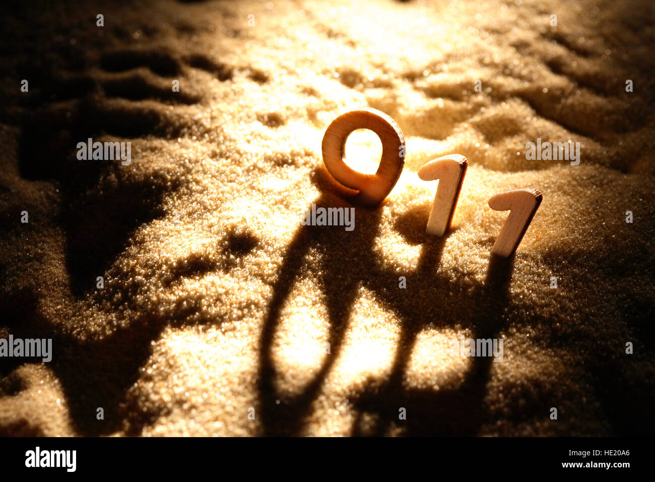 Emergency services concept. Wooden numbers 911 on sand background with shadow Stock Photo