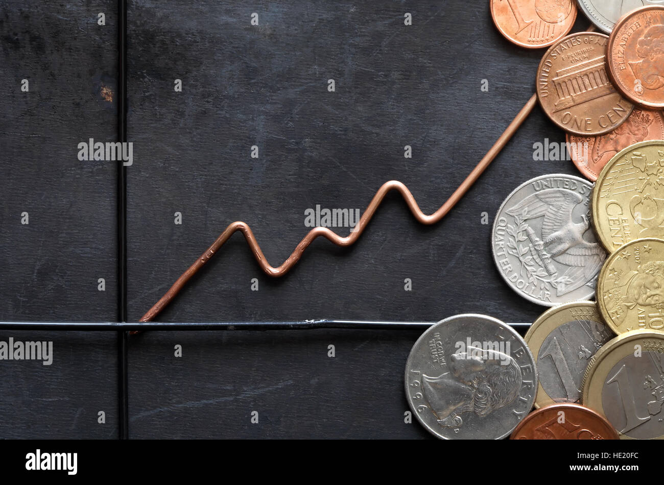 Business concept. Chart made from metal wire near coins on dark background Stock Photo