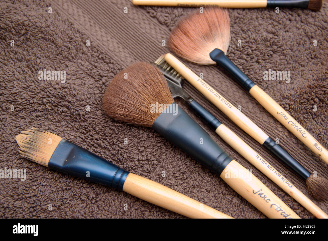 Ladies makeup brushes arranged on a brown towel. Stock Photo