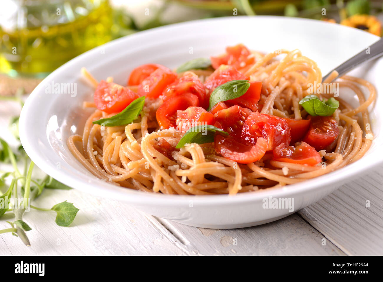 whole wheat spaghetti with chopped tomatoes garnished with basil leaves Stock Photo Alamy