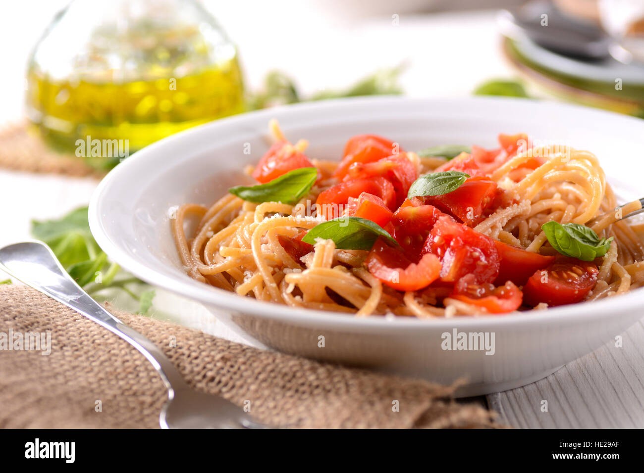 whole wheat spaghetti with chopped tomatoes garnished with basil leaves Stock Photo Alamy