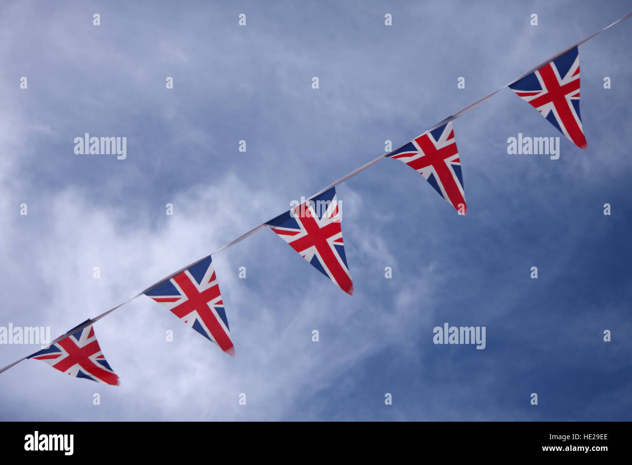 UK Union jack bunting flags in blue sky celebrating british culture Stock Photo